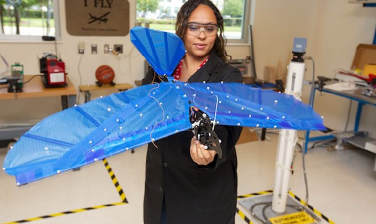 Woman holding her research flight model in NIA lab